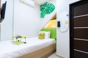 a small room with a bed and a table at Urbanview Hotel R House Batam in Jabi