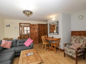 sala de estar con sofá y mesa en Penrose Cottage en Gilwern