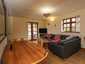 sala de estar con mesa y sofá en Penrose Cottage en Gilwern