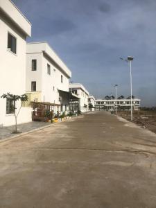 an empty street in front of white buildings at Your living & working sanctuary near Phnom Penh in Phumĭ Kândal (2)