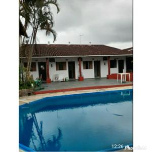 una casa con piscina frente a ella en Pousada Por do Sol, en Cananéia