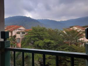 een balkon met uitzicht op een stad met bergen bij Homestay cikgu in Kamunting