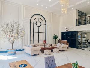 salon z białymi meblami i żyrandolem w obiekcie Sabina Luxury Boutique Hotel & Villa w mieście Vung Tau