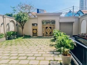 dom z dużymi złotymi drzwiami w ogrodzie w obiekcie Sabina Luxury Boutique Hotel & Villa w mieście Vung Tau