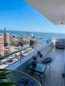 伊基克的住宿－Departamento con espectacular Ubicación, Vista al Mar y Panorámica a todo Iquique，阳台配有桌子,享有海景。