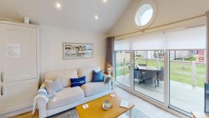 a living room with a couch and a table at Bay Breeze - Part of the The Bay Filey Holiday Village with pool, gym and direct beach access, pub, restaurant, tennis and meadows walks in Filey