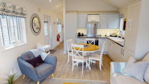 a kitchen and living room with a table and chairs at Bay Breeze - Part of the The Bay Filey Holiday Village with pool, gym and direct beach access, pub, restaurant, tennis and meadows walks in Filey +46 photos