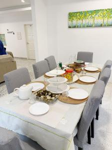 a dining room table with white plates on it at Kuala Terengganu Newly Renovated Nenda Beach House in Kuala Terengganu