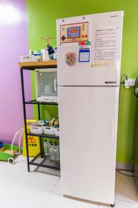 a white refrigerator in a kitchen next to a microwave at 宜家莊親子民宿 in Donggang