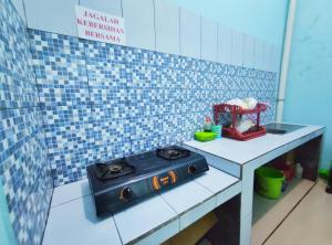 a toy kitchen with a stove on a counter at NgeKost harian in Alastuwo