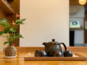 ein Tablett mit einem Wasserkocher und einer Vase auf dem Tisch in der Unterkunft 末廣通一館 日式包棟民宿 Suehirodori Japanese Entire Homes No1 in Tainan