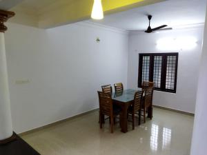 uma sala de jantar com mesa e cadeiras em Kizhakkethottam Homestays-River View Villa em Pala