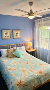 1 cama en un dormitorio con una pared azul en Dunsborough Beach House, en Quindalup