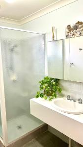 a bathroom with a sink and a glass shower at Dunsborough Beach House in Quindalup