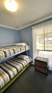 two bunk beds in a room with a window at Dunsborough Beach House in Quindalup