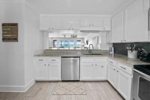 a white kitchen with white cabinets and a sink at Three Steps to the Beach Townhouse in Inlet Beach