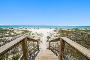 a boardwalk to the beach with the ocean in the background at Three Steps to the Beach Townhouse in Inlet Beach