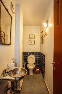 a bathroom with a sink and a toilet at Frishman beach 2Br full of art and light in Tel Aviv