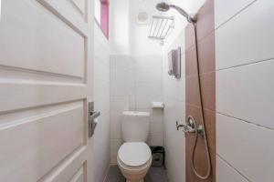 a small bathroom with a toilet and a shower at Urbanview Hotel Ananda Syariah by RedDoorz in Bukittinggi