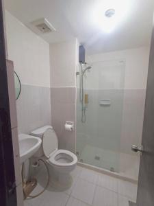 a bathroom with a shower and a toilet and a sink at Studio unit at Mesaverte Residence in Cagayan de Oro