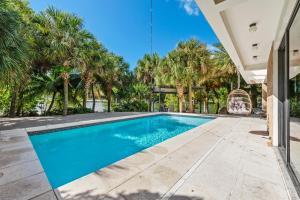 een zwembad in een tuin met palmbomen bij Villa Bali in Miami