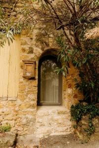 a window in a stone building with a door at La petite maison in Lourmarin