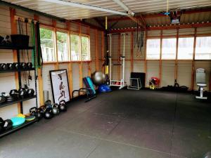 a large room with a gym with lots of equipment at Peace and Aroha Mangawhai - Apartment in Mangawhai