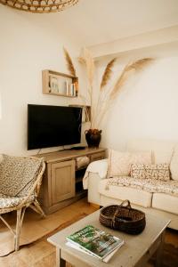 a living room with a couch and a tv at La petite maison in Lourmarin