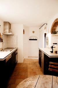 a kitchen with white counters and a wooden floor at La petite maison in Lourmarin