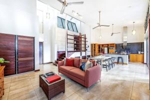 a large living room with a couch and a kitchen at 'Troppo' Darwin Designer Luxury Boutique Home in Paraparap