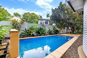una piscina en el patio de una casa con una valla en 'Troppo' Darwin Designer Luxury Boutique Home, en Parap