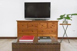 a television sitting on top of a dresser with a table at 'Troppo' Darwin Designer Luxury Boutique Home in Paraparap