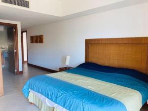 um quarto com uma cama grande e uma cabeceira em madeira em Condominio en Ixtapa frente a la playa em Ixtapa