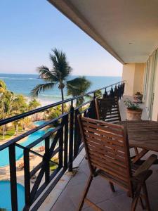 a balcony with a bench and a view of the ocean at Condominio en Ixtapa frente a la playa in Ixtapa