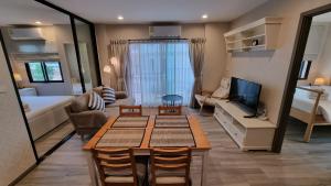 un soggiorno con tavolo, divano e TV di D4 The Title Residencies Naiyang Two Bedroom Phuket a Nai Yang Beach