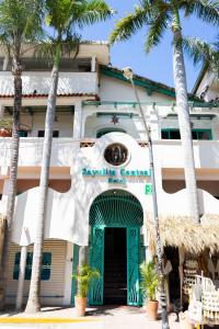 un bâtiment avec une porte verte et des palmiers dans l'établissement Sayulita Central Hotel, à Sayulita