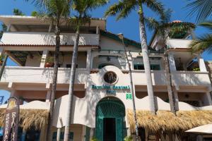 a building with palm trees in front of it at Sayulita Central Hotel in Sayulita
