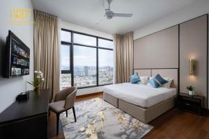 um quarto com uma cama, uma secretária e uma janela grande em Pavilion Embassy Suites KL em Kuala Lumpur
