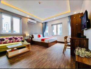 a hotel room with a bed and a couch at Delicate Serviced Apartment And Hotel in Da Nang
