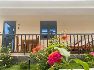 uma varanda com cadeiras e flores no quintal em LAM BUNGALOW Resort & Spa em Phu Quoc