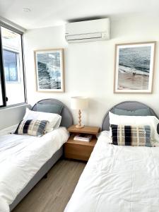 Duas camas sentadas uma ao lado da outra num quarto em Monterey Lodge - Unit 18, 27 Warne Terrace, Kings Beach Caloundra em Caloundra