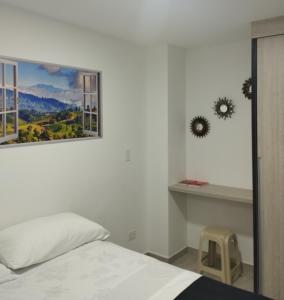 1 dormitorio con 1 cama y una foto en la pared en Apartamento Almendros Home, en Santa Rosa de Cabal