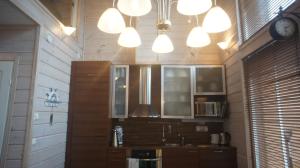 a kitchen with wooden walls and lights and a sink at Kiurun Villas in Imatra