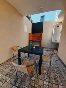 a patio with a table and chairs in a room at Apart km4 in Comodoro Rivadavia