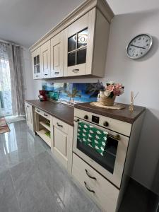 a kitchen with an oven and a clock on the wall at City Center Sunny Apartment in Suceava