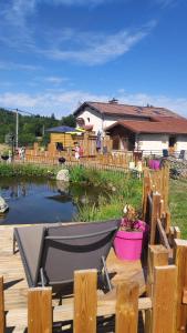 krzesło na drewnianym tarasie obok stawu w obiekcie Le Moulin de la Fortie, Gîtes w mieście Viscomtat