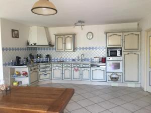 une cuisine avec des placards bleus et blancs et une table dans l'établissement Belle longere 130 m2 aux portes du marais poitevin, à Niort