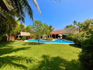 a yard with a swimming pool and a house at Coconut Paradise Holiday Villas in Rawai Beach