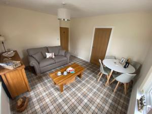 a living room with a couch and a table at The Burrow, Langholm, Dumfries and Galloway in Langholm