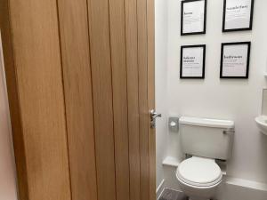 a bathroom with a toilet and three pictures on the wall at The Burrow, Langholm, Dumfries and Galloway in Langholm
